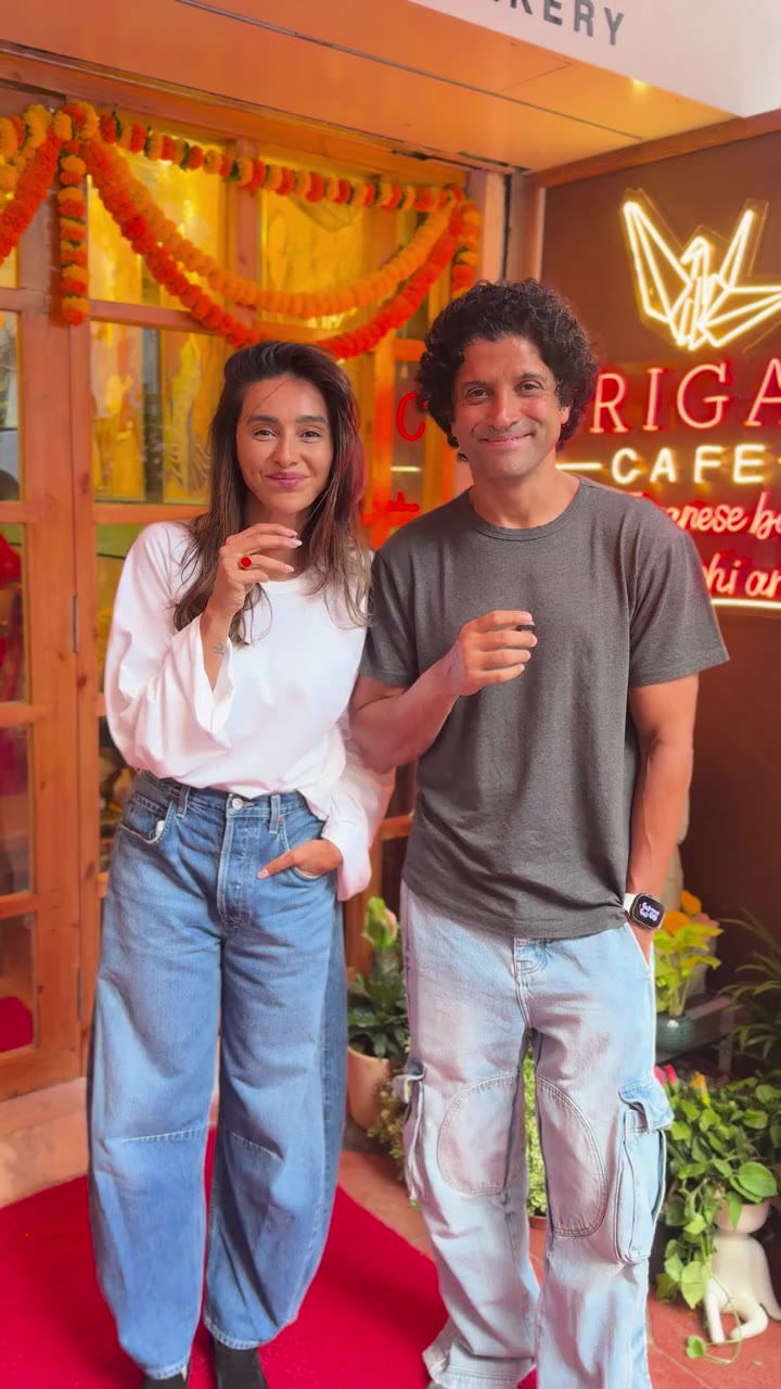 Two guests smiling outside Origami Café during the conversation